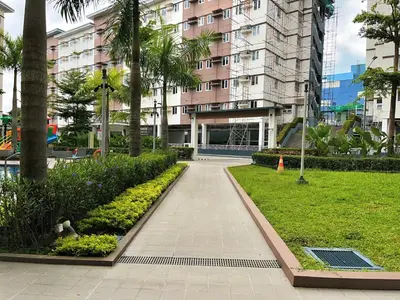 a walkway in front of a building with palm trees at Elim Escape Staycation in Trece Martires