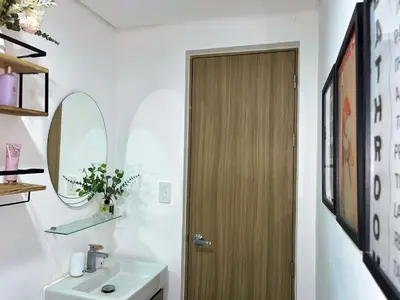 a bathroom with a sink and a wooden door at Elim Escape Staycation in Trece Martires