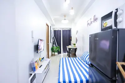 a living room with a blue and white striped couch at Elegant yet Affordable condo in Pasay in Manila