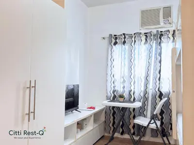 a room with a window with a chair and a television at Studio City Alabang Pool Access Free for 2 Wifi & Netflix SC4 in Manila