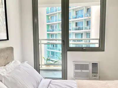 a bedroom with a window with a view of a building at Azure Boracay Tower 1BR in Manila