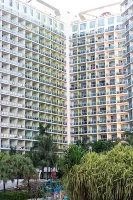 a large building with palm trees in front of it at Azure Boracay Tower 1BR in Manila