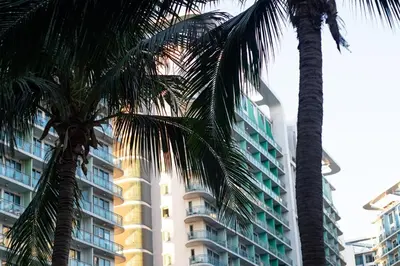 two palm trees in front of a building at Azure Boracay Tower 1BR in Manila