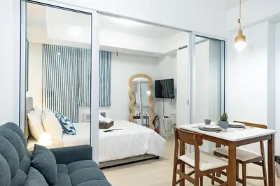 a bedroom with a bed and a table and a couch at Azure Boracay Tower 1BR in Manila