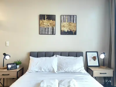 a bedroom with a bed with three pictures on the wall at 1BR Amazing View Condo in Uptown BGC by Terravista in Manila