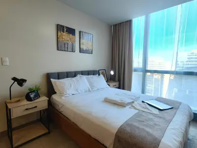 a bedroom with a bed with a laptop on it at 1BR Amazing View Condo in Uptown BGC by Terravista in Manila