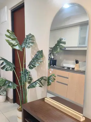 a kitchen with a table and a plant in a mirror at 1BR Amazing View Condo in Uptown BGC by Terravista in Manila