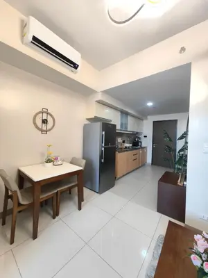 a kitchen and dining room with a table and a refrigerator at 1BR Amazing View Condo in Uptown BGC by Terravista in Manila