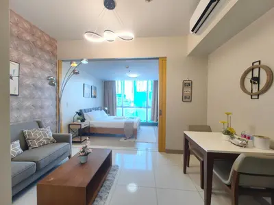 a living room with a couch and a bed at 1BR Amazing View Condo in Uptown BGC by Terravista in Manila