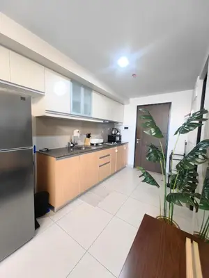 a kitchen with wooden cabinets and a stainless steel refrigerator at 1BR Amazing View Condo in Uptown BGC by Terravista in Manila