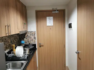 a kitchen with a wooden door and a sink at Mall of Asia Shore condo in Manila