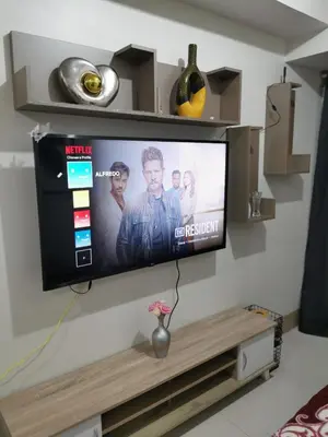a flat screen tv hanging on a wall at Mall of Asia Shore condo in Manila