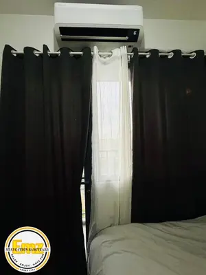 a bed with black curtains next to a window at EMZ SHORE2 Staycation 16 in Manila