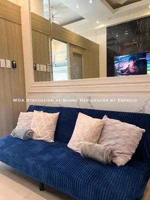 a blue couch with pillows on it in a room at Ezpacio in Manila