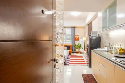a kitchen with a stainless steel refrigerator and a living room at Roam & Rest Staycation near NAIA Manila Airport and free WiFi in Manila