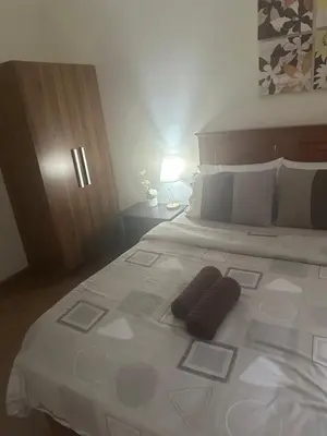 a large bed with two pillows on top of it at Casa Delantera Karaoke Games Pet Friendly in Manila