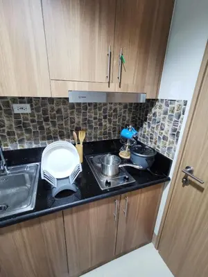 a small kitchen with a stove and a sink at Mall of Asia shore 3 condotel in Manila