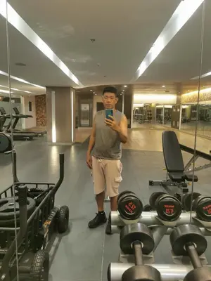 a man standing in a gym looking at his cell phone at Mao condotel shore 3 Pasay in Manila