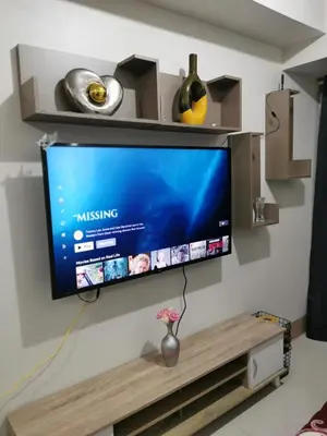 a flat screen tv hanging on a wall at Mao condotel shore 3 Pasay in Manila