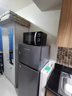 a kitchen with a microwave on top of a refrigerator at Mao condotel shore 3 Pasay in Manila