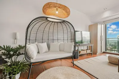 a living room with a white couch in a swing at Native studio hideaway in the heart of Poblacion, Makati in Manila