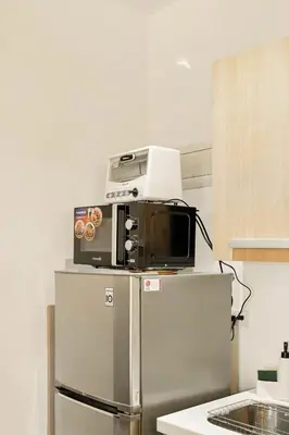 a microwave on top of a refrigerator in a kitchen at Native studio hideaway in the heart of Poblacion, Makati in Manila