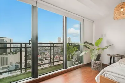 a bedroom with a large window with a view of the city at Native studio hideaway in the heart of Poblacion, Makati in Manila