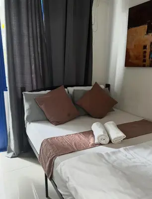 a bed in a room with two towels on it at Stayscape Ph in Manila