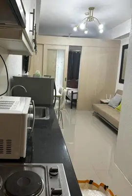 a kitchen with a stove and a living room at Stayscape Ph in Manila