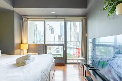 a bedroom with a bed and a large window at Central Stay w King bed near Greenbelt 55-In TV in Manila
