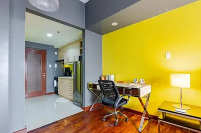 an office with a desk and a chair in a room at Central Stay w King bed near Greenbelt 55-In TV in Manila