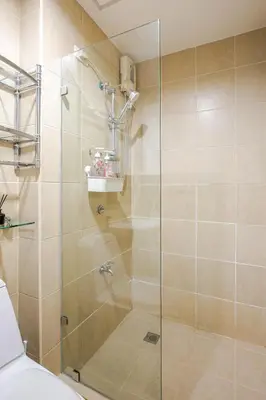 a shower with a glass door in a bathroom at Central Stay w King bed near Greenbelt 55-In TV in Manila