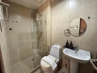 a bathroom with a shower and a toilet and a sink at Tropical Wood Studio w Balcony Near Greenbelt Pool and Gym Access in Manila