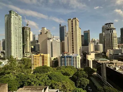 a view of a city with tall buildings at Tropical Wood Studio w Balcony Near Greenbelt Pool and Gym Access in Manila