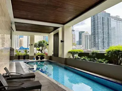 a hotel swimming pool with a view of the city at Tropical Wood Studio w Balcony Near Greenbelt Pool and Gym Access in Manila