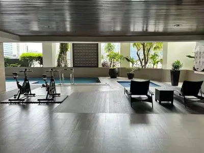 a gym with exercise bikes and chairs in a building at Tropical Wood Studio w Balcony Near Greenbelt Pool and Gym Access in Manila
