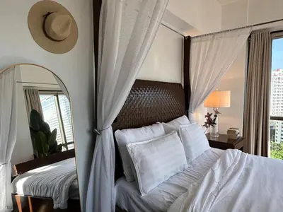 a bedroom with a white bed with a large mirror at Tropical Wood Studio w Balcony Near Greenbelt Pool and Gym Access in Manila