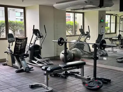a gym with several exercise bikes and tread machines at Tropical Wood Studio w Balcony Near Greenbelt Pool and Gym Access in Manila