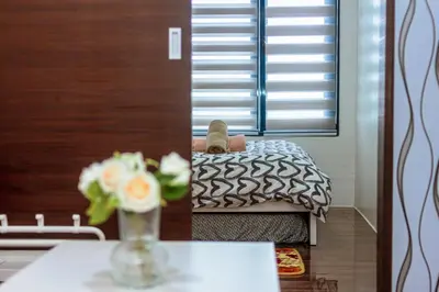 a person laying on a bed in a bedroom at The Zen Escape 1BR Makati swim gym park cook 300MB 5940 in Manila