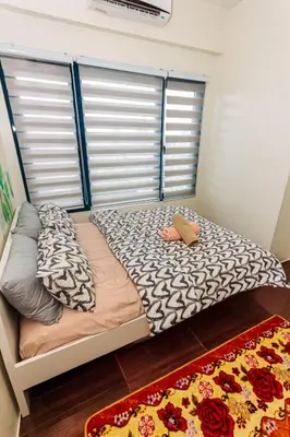 a small bed in a room with two pillows at The Zen Escape 1BR Makati swim gym park cook 300MB 5940 in Manila