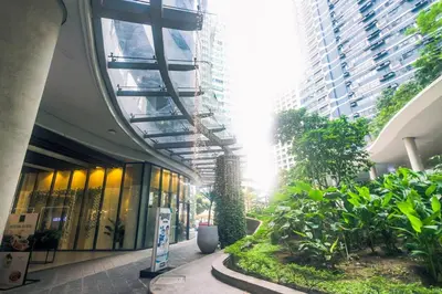 a building with a hallway with plants and buildings at The Zen Escape 1BR Makati swim gym park cook 300MB 5940 in Manila