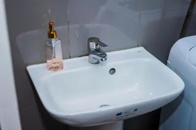 a bathroom sink with a bottle on top of it at The Greenbelt Groove 1BR Makati 300MB swim gym park 4034 in Manila
