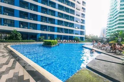 a large swimming pool in front of a building at The Greenbelt Groove 1BR Makati 300MB swim gym park 4034 in Manila