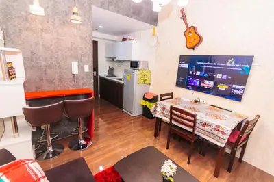 a kitchen and dining room with a table and a guitar on the wall at The Greenbelt Groove 1BR Makati 300MB swim gym park 4034 in Manila