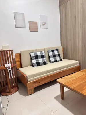 a couch with two pillows on it in a living room at Fame Residences 1br unit by LaBelle in Manila