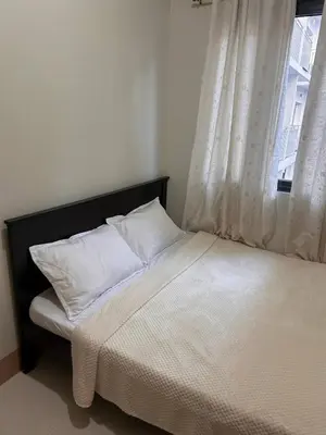 a bed with white pillows in a room with a window at 1Bedroom Condo at Shore Near Airport & MOA Balcony Pool View in Manila