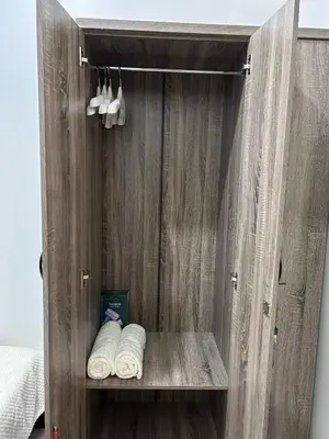 a wooden cabinet with three rolls of towels in it at 1Bedroom Condo at Shore Near Airport & MOA Balcony Pool View in Manila