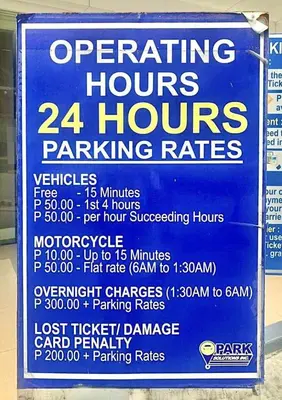 a sign for operating hours and hours parking rates at 1Bedroom Condo at Shore Near Airport & MOA Balcony Pool View in Manila