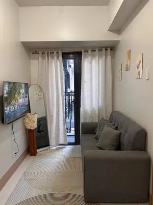 a living room with a couch and a tv at 1Bedroom Condo at Shore Near Airport & MOA Balcony Pool View in Manila