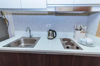a kitchen counter with a sink and a stove at Makati Bliss Designer Stay Pool gym park Net300 makati 1767 in Manila